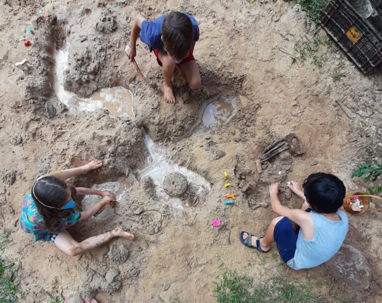 Crianças brincando na terra, ao ar livre
