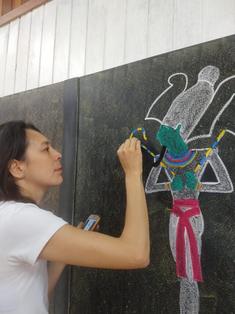 Professora desenhando no quadro-negro da sala de aula